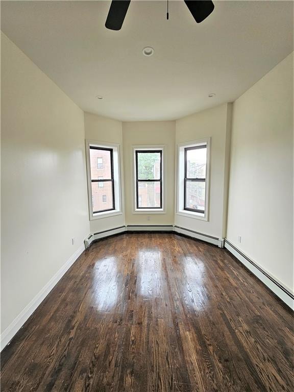 empty room with ceiling fan and dark hardwood / wood-style flooring