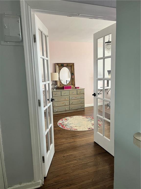 doorway to outside with an inviting chandelier, dark hardwood / wood-style floors, electric panel, and french doors