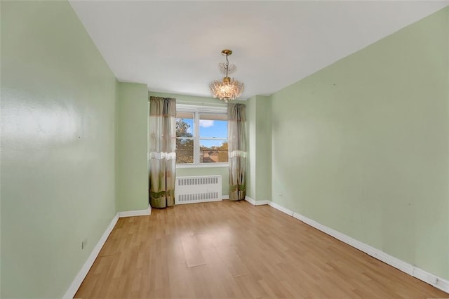 unfurnished dining area featuring a chandelier, baseboards, light wood-style flooring, and radiator heating unit