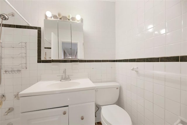 full bathroom with toilet, vanity, and tile walls