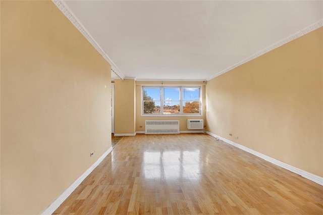 empty room with crown molding, radiator heating unit, light hardwood / wood-style floors, and a wall unit AC