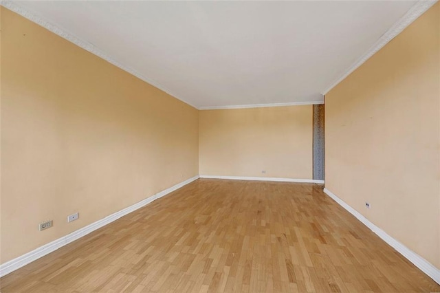 unfurnished room with light wood-type flooring, crown molding, and baseboards