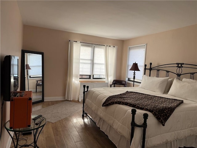 bedroom with baseboards and wood finished floors
