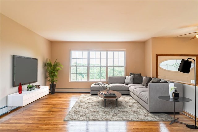 living room with ceiling fan, light wood-type flooring, and a baseboard heating unit