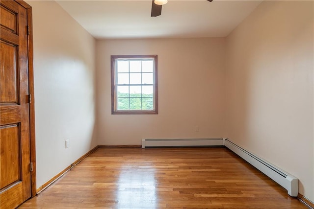 spare room with light hardwood / wood-style floors, ceiling fan, and a baseboard radiator