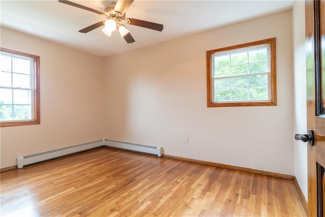 spare room with light wood-type flooring, ceiling fan, and a baseboard heating unit