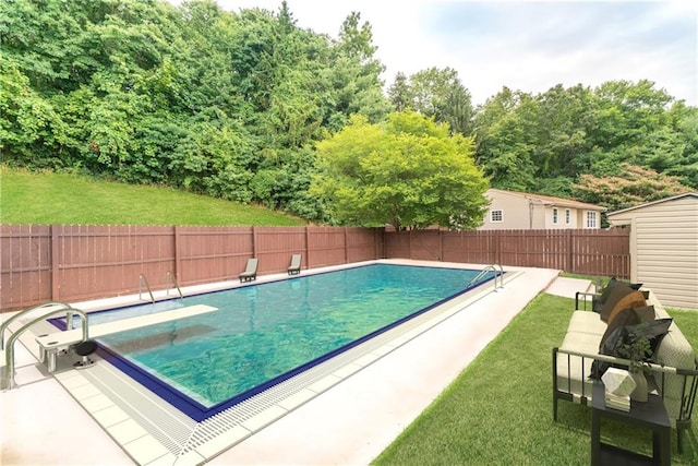 view of pool with a diving board and a yard