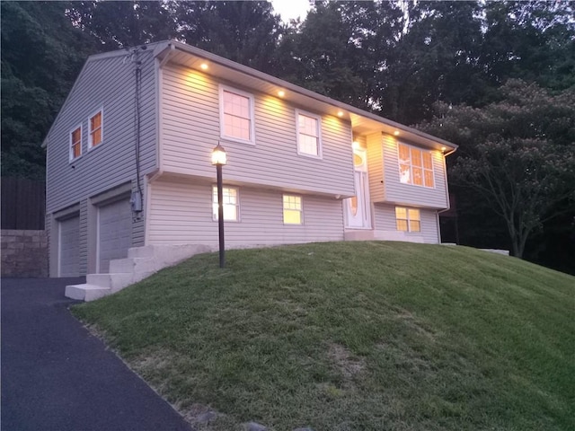 bi-level home featuring a garage and a front yard