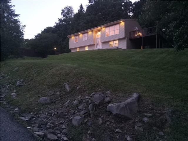 view of front of home with a lawn and a deck