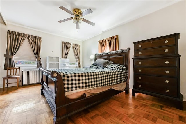 bedroom with radiator heating unit, ceiling fan, and parquet floors