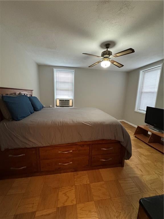 bedroom with a textured ceiling, cooling unit, and ceiling fan