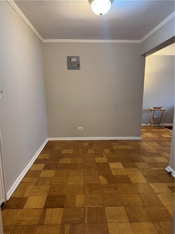 empty room featuring ornamental molding, electric panel, and baseboards