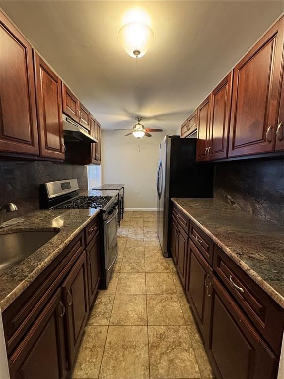 kitchen with appliances with stainless steel finishes, under cabinet range hood, decorative backsplash, and a ceiling fan