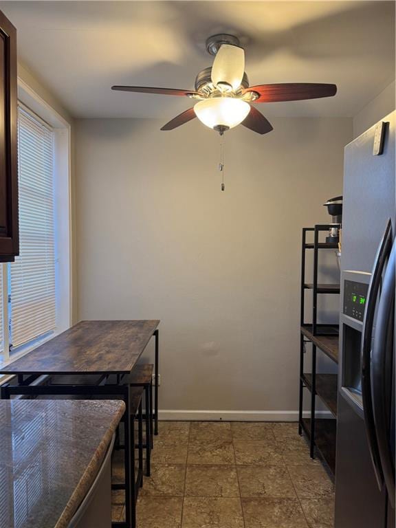 kitchen featuring ceiling fan, sink, dark stone countertops, and stainless steel appliances