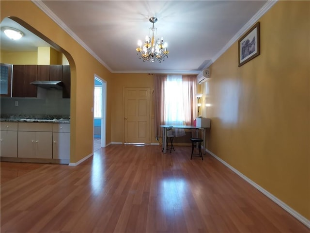 interior space featuring wood-type flooring, an inviting chandelier, a wall mounted AC, and crown molding