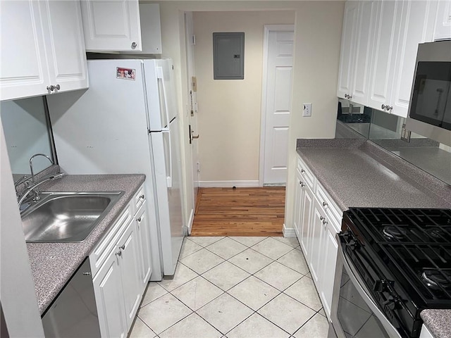 kitchen featuring light tile patterned floors, white cabinetry, electric panel, and stainless steel appliances