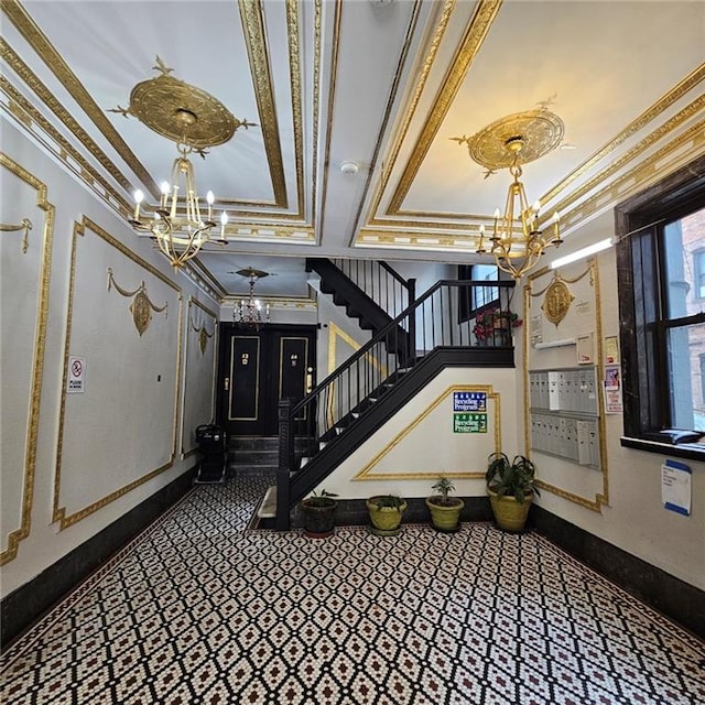 stairway with crown molding, a chandelier, and a tray ceiling