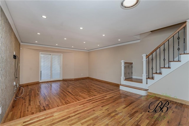 unfurnished living room with ornamental molding, recessed lighting, wood finished floors, and baseboards