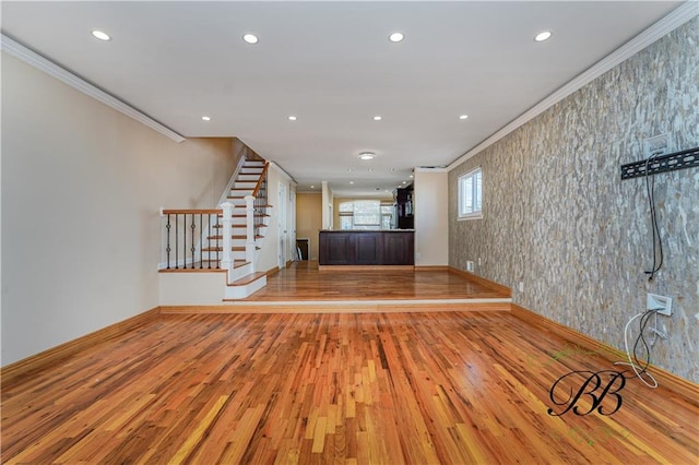 unfurnished living room featuring recessed lighting, wood finished floors, and crown molding