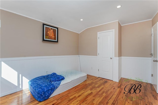 bedroom featuring ornamental molding, wainscoting, wood finished floors, and recessed lighting