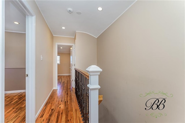 corridor with recessed lighting, an upstairs landing, baseboards, light wood-type flooring, and crown molding