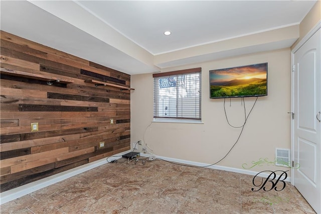 spare room with recessed lighting, wooden walls, an accent wall, visible vents, and baseboards