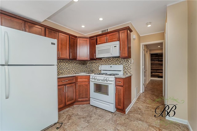 kitchen featuring white appliances, tasteful backsplash, a sink, and recessed lighting