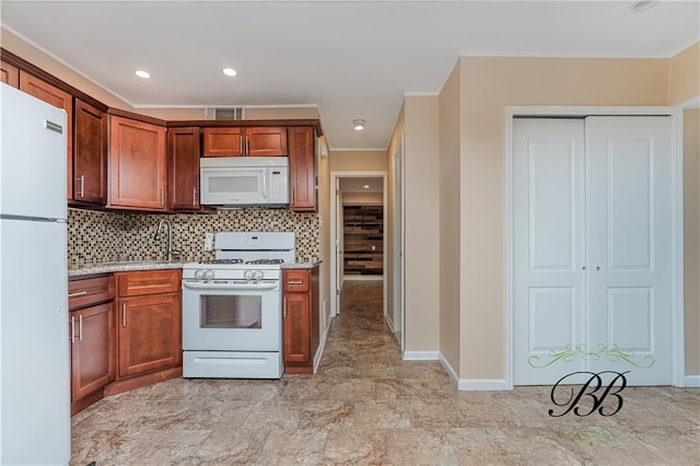 kitchen featuring crown molding, visible vents, decorative backsplash, white appliances, and baseboards