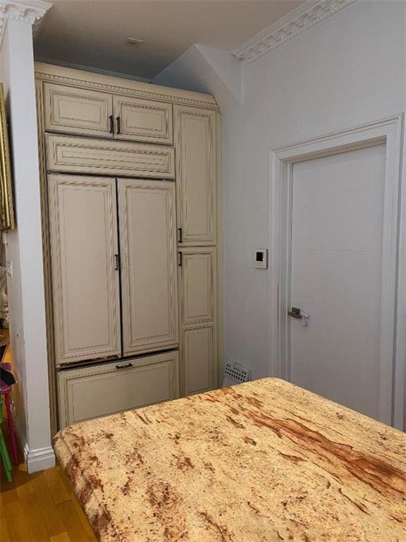 bedroom featuring crown molding and light hardwood / wood-style flooring