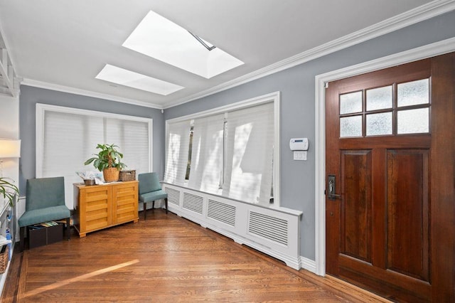 foyer with a skylight, hardwood / wood-style flooring, and crown molding