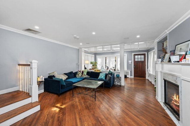 living room with dark hardwood / wood-style flooring, a premium fireplace, and crown molding