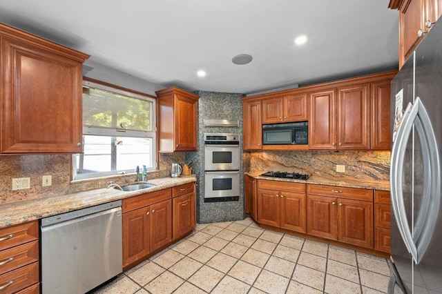 kitchen with backsplash, light stone counters, sink, and stainless steel appliances