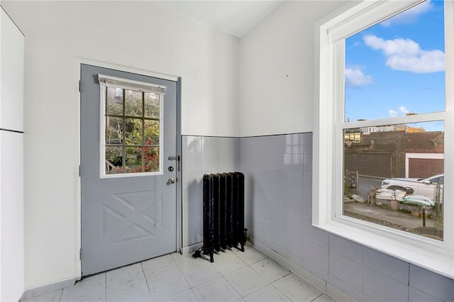 doorway with radiator heating unit and tile walls