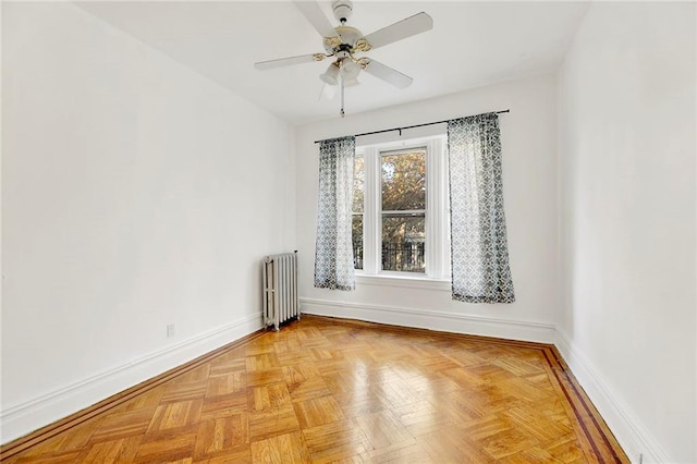 unfurnished room with light parquet flooring, radiator, and ceiling fan