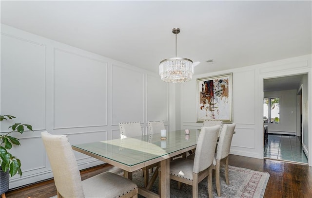 dining space featuring dark wood-type flooring and a chandelier