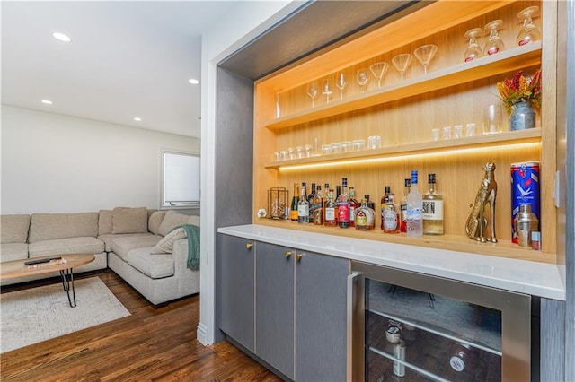 bar featuring gray cabinets, dark wood-type flooring, and beverage cooler