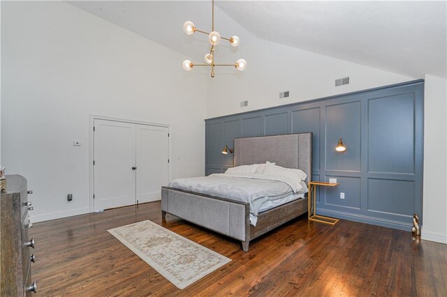 bedroom featuring dark hardwood / wood-style floors, an inviting chandelier, and high vaulted ceiling