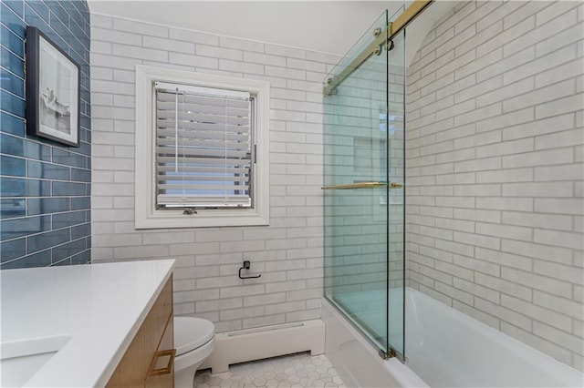 full bathroom featuring vanity, bath / shower combo with glass door, tile patterned flooring, a baseboard heating unit, and toilet