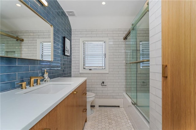 full bathroom featuring bath / shower combo with glass door, tile patterned flooring, a healthy amount of sunlight, and toilet