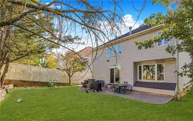 rear view of house featuring a lawn and a patio area