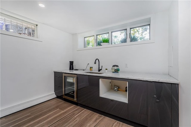 bar with a baseboard radiator, sink, dark hardwood / wood-style floors, light stone countertops, and wine cooler