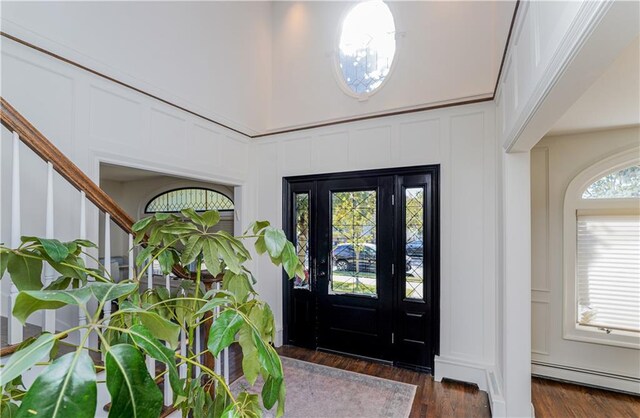 foyer featuring baseboard heating and dark wood-type flooring