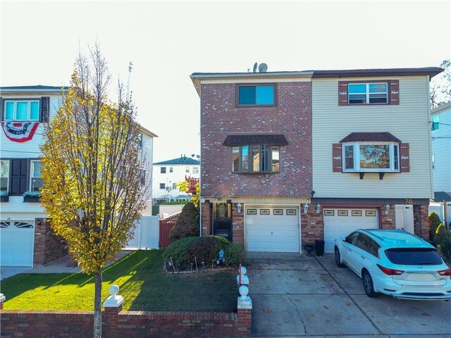 view of property with a garage and a front lawn