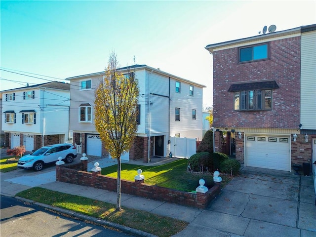 townhome / multi-family property featuring a garage and a front lawn