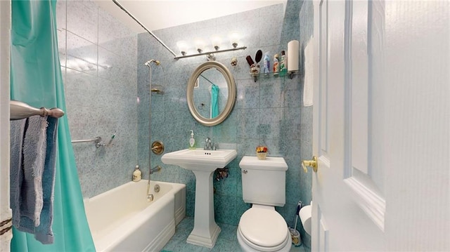 full bathroom with shower / tub combo with curtain, sink, tile walls, and toilet