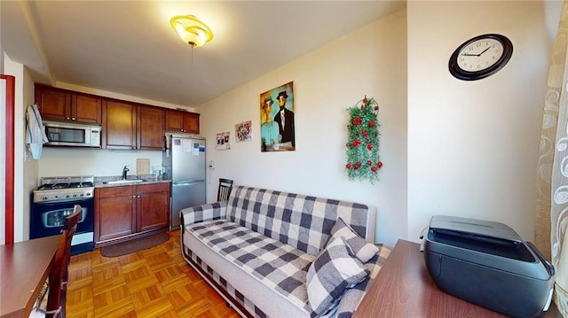 kitchen featuring stainless steel appliances, light parquet flooring, and sink