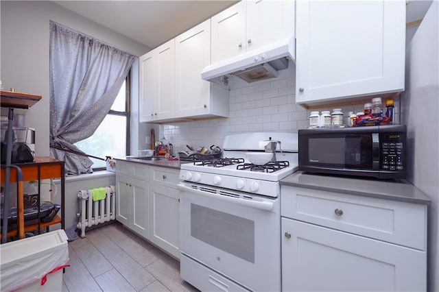 543 49th St, Brooklyn, NY 11220 - kitchen with black microwave, radiator, white cabinetry, white range with gas stovetop, and under cabinet range hood