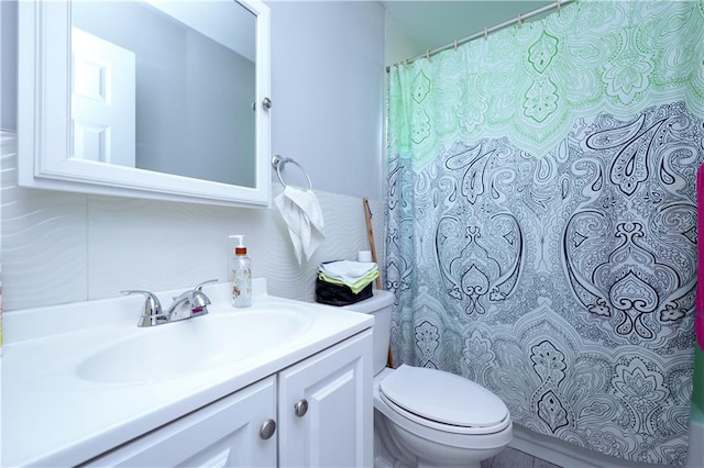 bathroom featuring decorative backsplash, vanity, and toilet