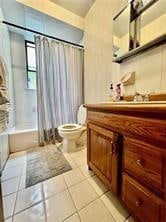 full bathroom featuring vanity, tile patterned flooring, toilet, and shower / tub combo