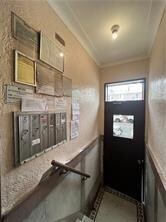 entryway featuring mail boxes and ornamental molding